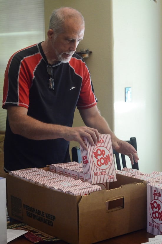 Paul arranging boxes of popcorn inside a large box.