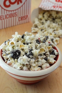 A bowl of white chocolate coated popcorn and oreo bits in a bowl.