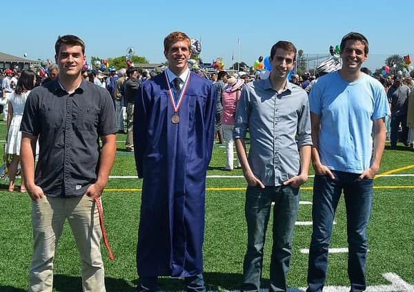 A group of young man posing for the camera at a graduation.