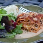 Lasagna and salad on a plate.