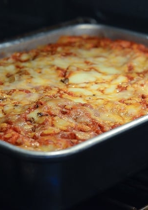 Lasagna in a metal pan in the oven.