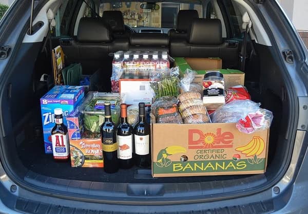 A car full of groceries with the trunk open.