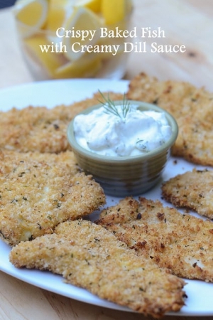 Breaded fish on a plate with creamy dill sauce.