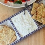 Tzatziki and toasted pitas in a serving dish.