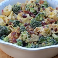 A bowl of tortellini with broccoli and bacon.