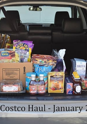 A car trunk open and filled with groceries.