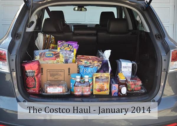 A car trunk open and filled with groceries.