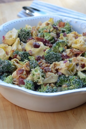 A bowl of tortellini with broccoli and bacon.