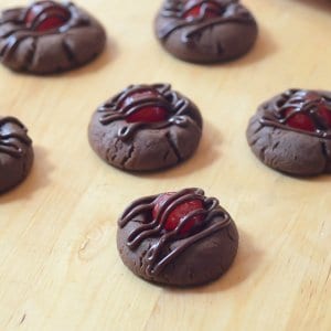 Chocolate cookies topped with cherries and drizzled with chocolate.