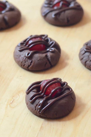 Chocolate cookies topped with cherries and drizzled with chocolate.