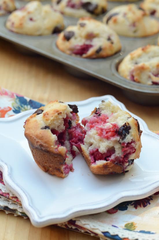 A Raspberry Dark Chocolate Muffin is broken open to reveal the inside.