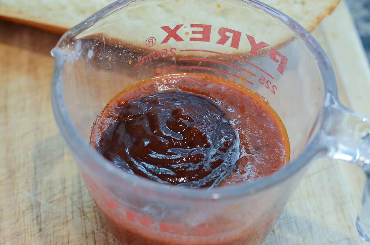 Marinara and BBQ sauce in a measuring cup.