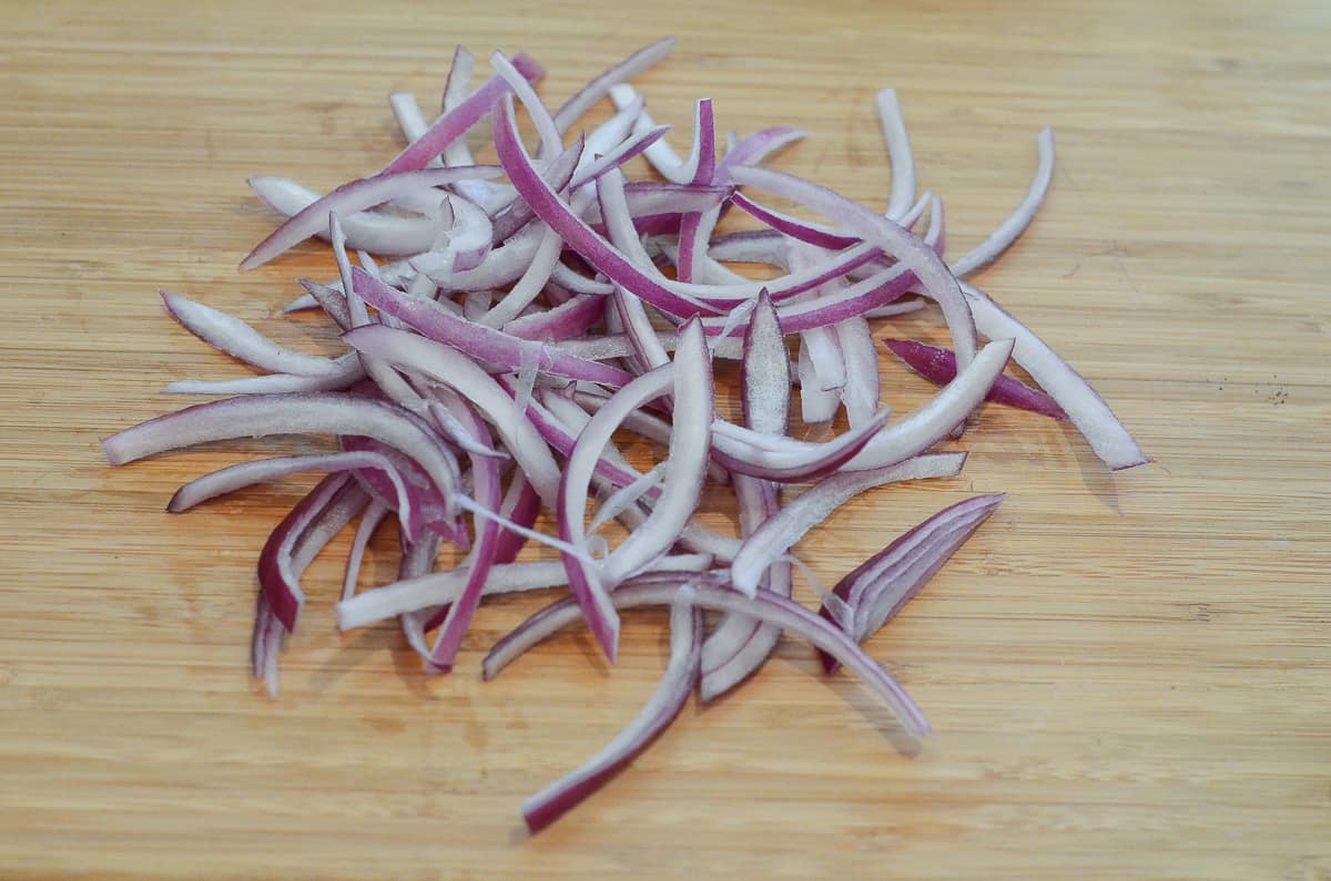 Sliced red onion on a cutting board.