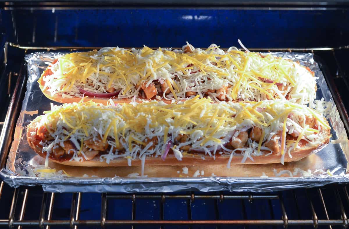 French bread pizza baking in an oven.