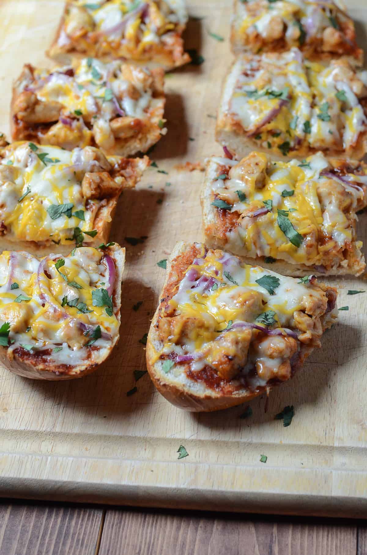 Slices of BBQ Chicken French Bread Pizza on a cutting board.