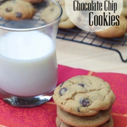 A stack of cookies next to a cup of milk.
