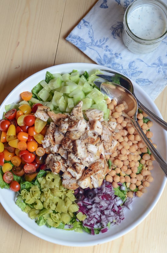 A large serving bowl full of Mediterranean Chicken Chopped Salad with Creamy Feta Dill Dressing