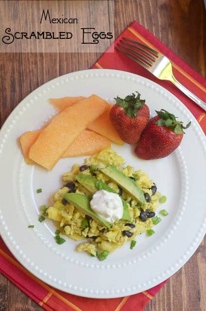 Mexican Scrambled Eggs on a white plate with fruit.