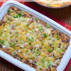A baking dish full of bean dip with melted cheese.