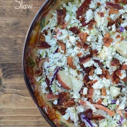 A bowl of coleslaw with bacon and blue cheese.