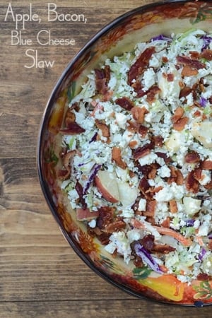 A bowl of coleslaw with bacon and blue cheese.