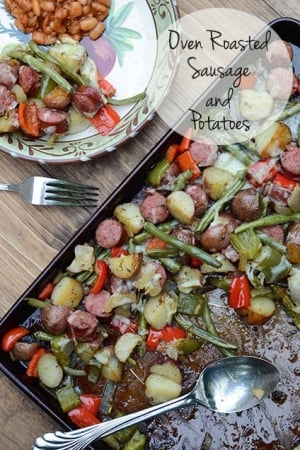 Sausage, potatoes, and green beans on a baking sheet.