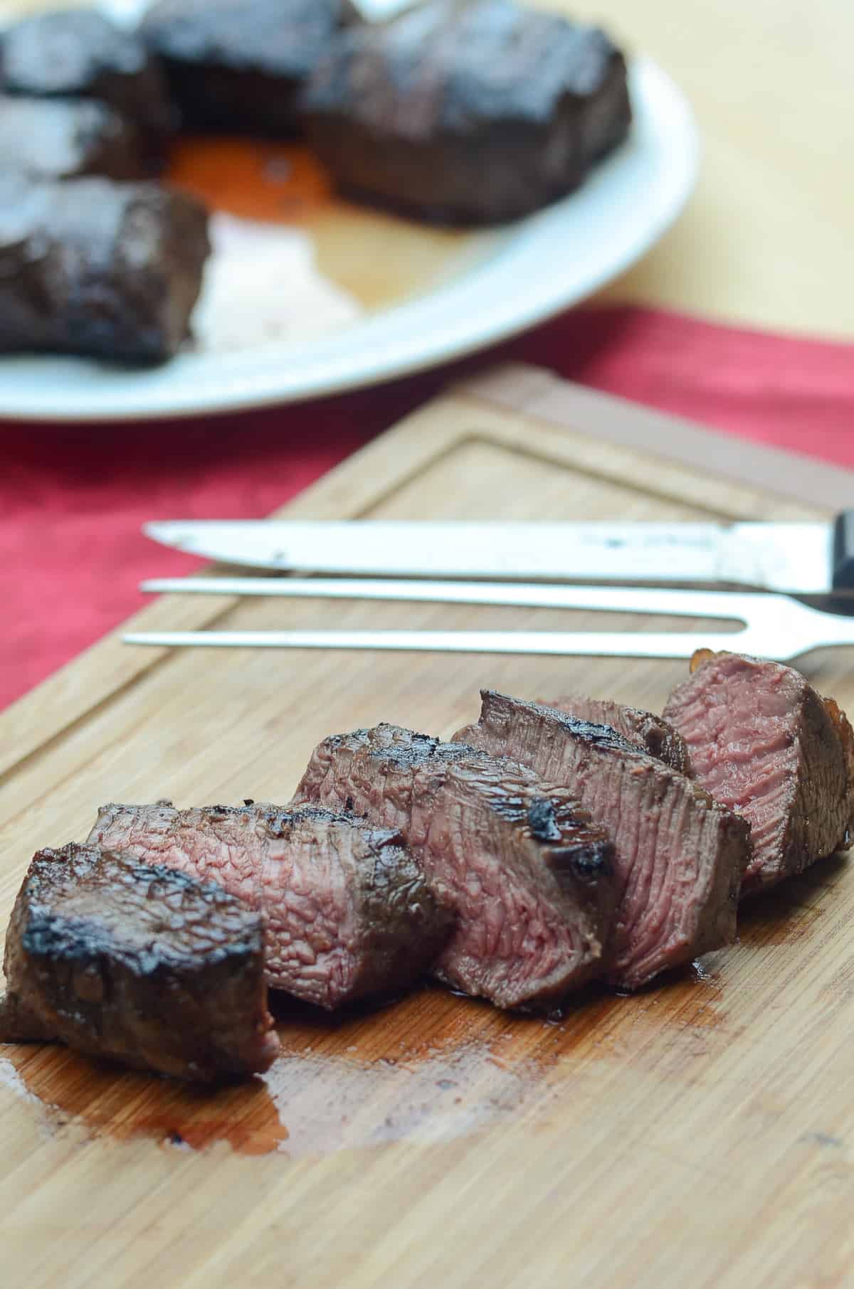 Sliced steak on a cutting board.