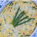 A baked egg dish topped with asparagus.
