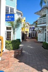 A brick planter in front of colorful buildings.