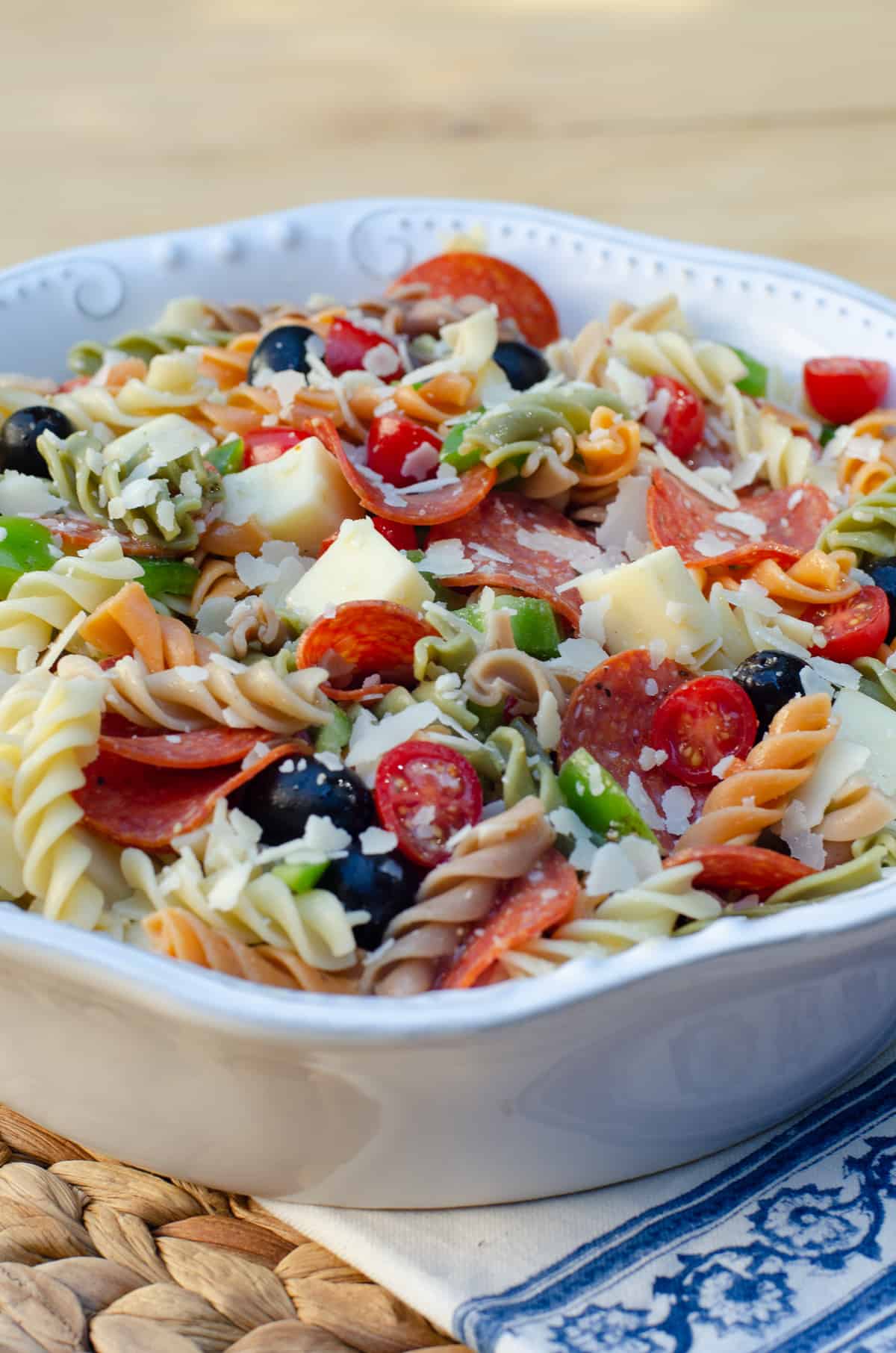 Pizza Pasta Salad in a white bowl on a blue and white cloth.