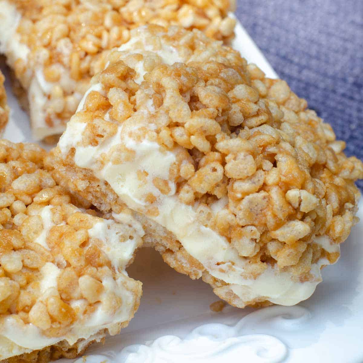Peanut butter rice krispie ice cream sandwiches on a white platter.