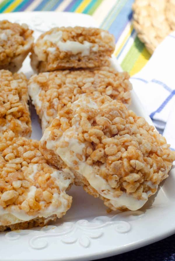 Peanut butter rice krispie ice cream sandwiches on a white platter.