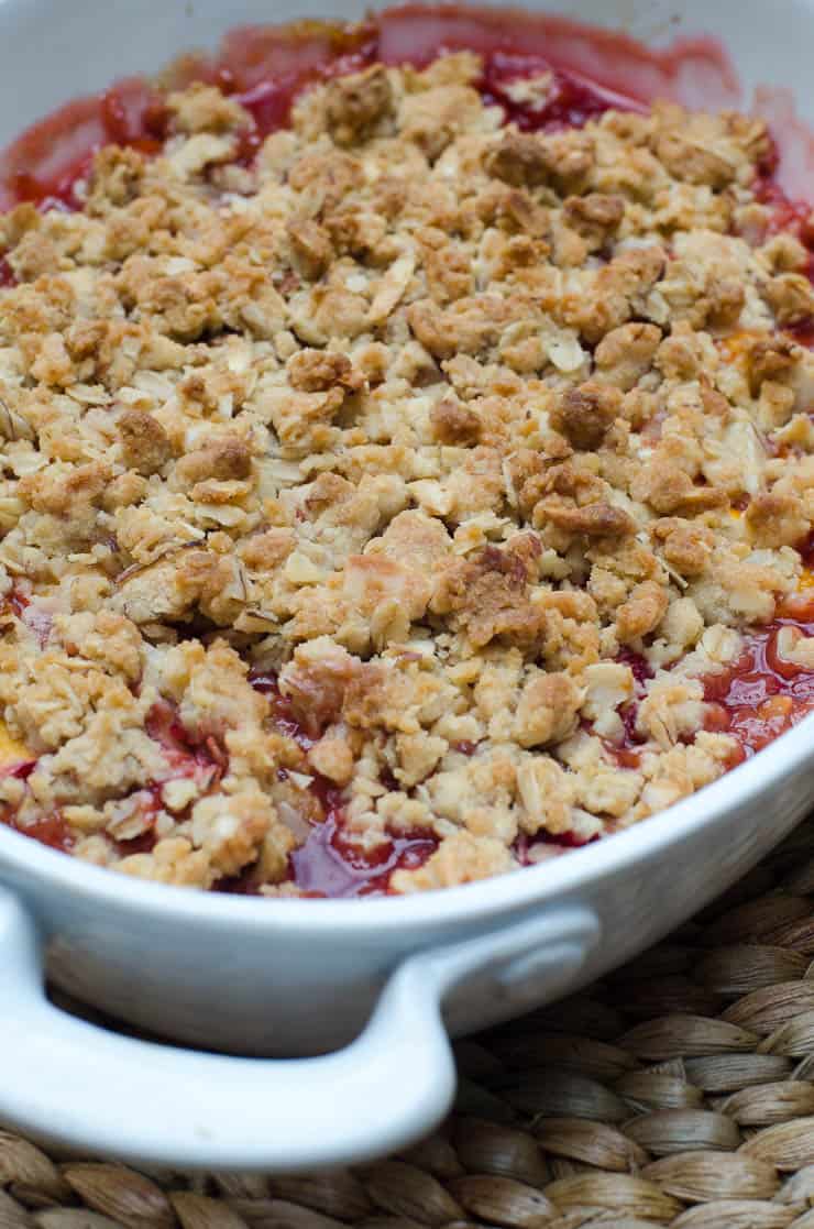 Peach Strawberry Crisp in a white baking dish.