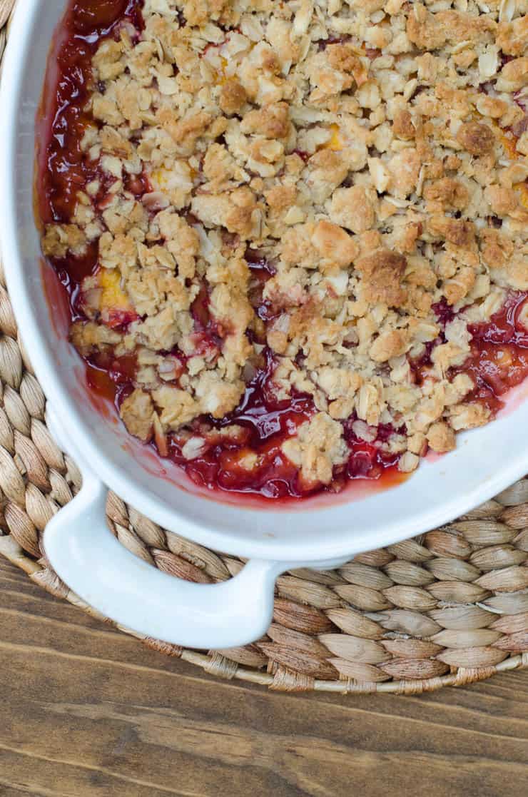 An over the top shot of Peach Strawberry Crisp in a white baking dish.