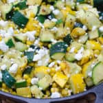 Zucchini and corn with feta in a cast iron skillet.