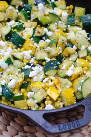 Zucchini and corn with feta in a cast iron skillet.