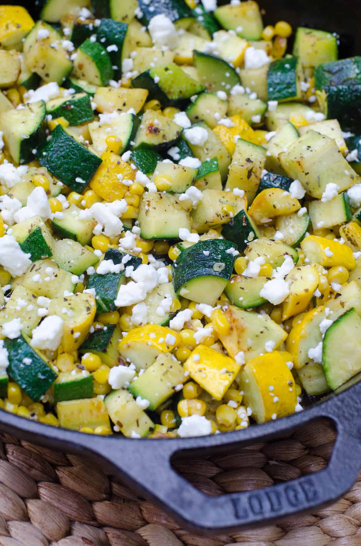 Zucchini and corn with feta in a cast iron skillet.
