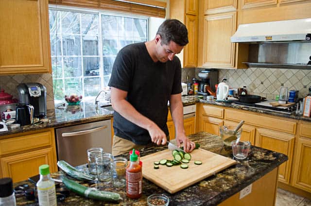 Ryan slicing the English cucumbers on a cutting board.