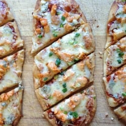 Flatbread pizza on a cutting board.
