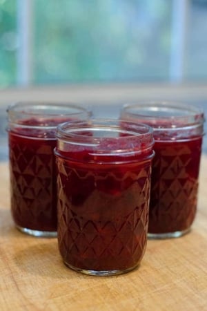 Mason jars filled with cranberry sauce.
