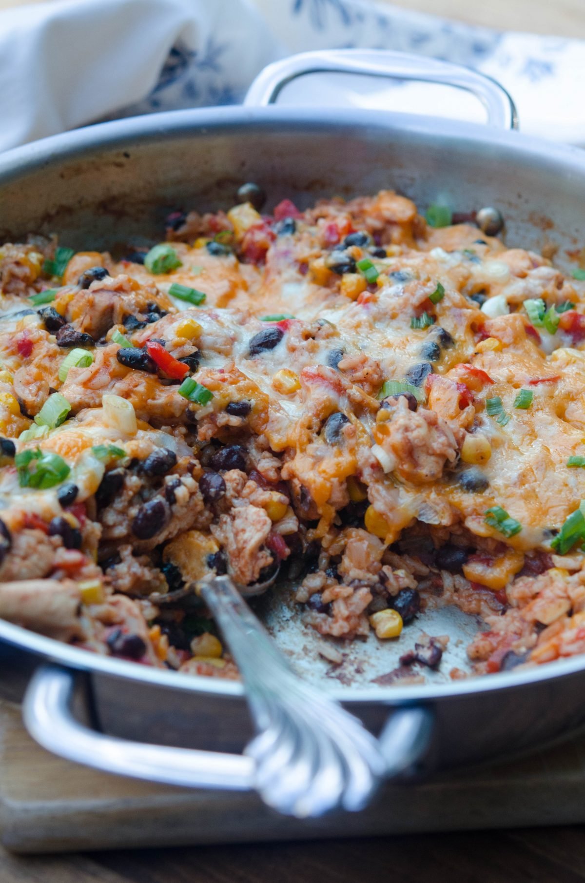 A spoon scoops up some Tex-Mex Chicken and Rice from the skillet.