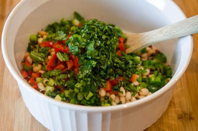 The bean mixture is combined in a white bowl.