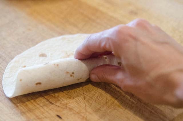 A tortilla is rolled up with the egg mixture inside.