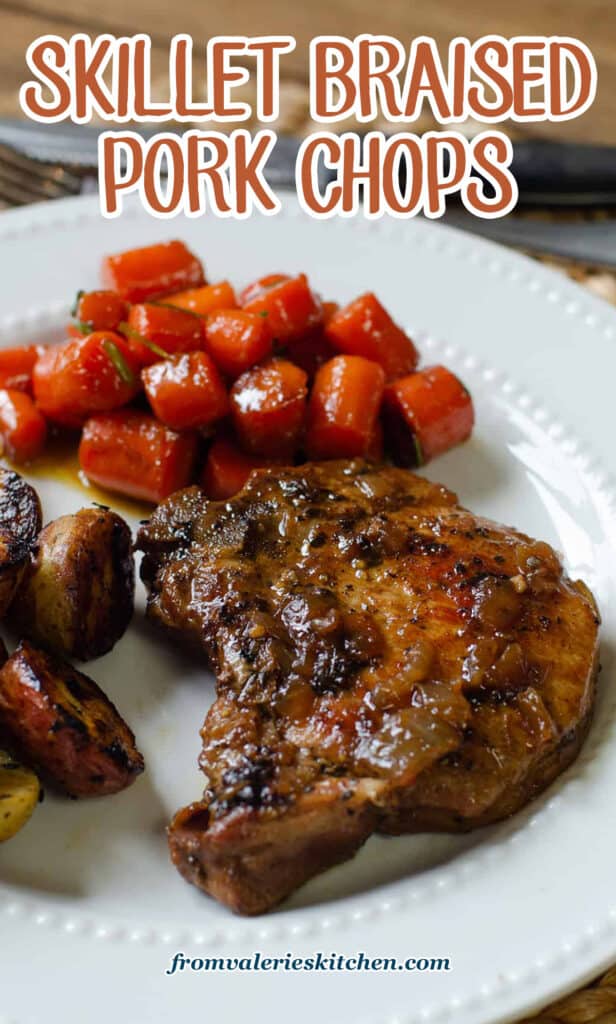 A pork chop on a white plate with carrots and potatoes with text.