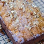 A loaf of banana bread with glaze and nuts.
