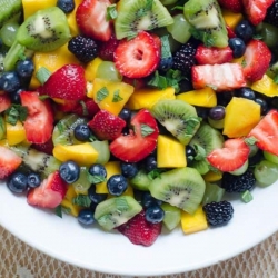 A white bowl filled with fruit salad.