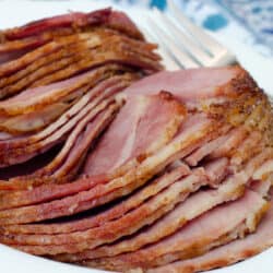 Sliced spiral ham on a white platter.