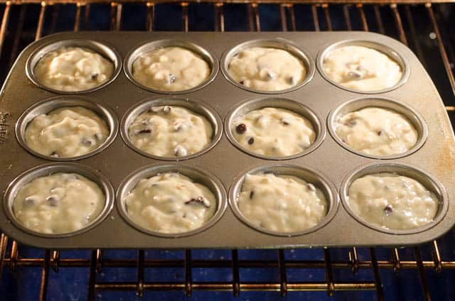 The muffin batter in a muffin pan baking in the oven.