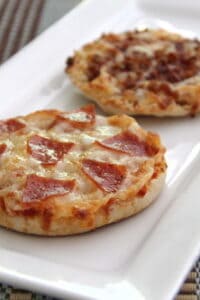 Two English muffin pizzas on a white serving tray.