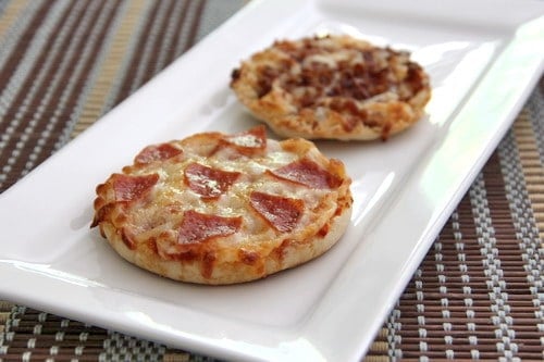 Two English muffin pizzas on a white serving tray.